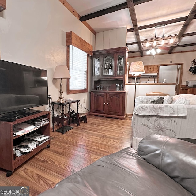 living area with beam ceiling and light wood-style flooring