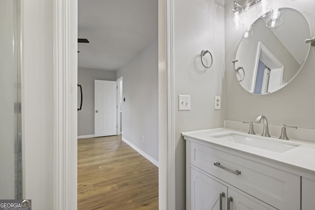 bathroom with vanity, baseboards, and wood finished floors