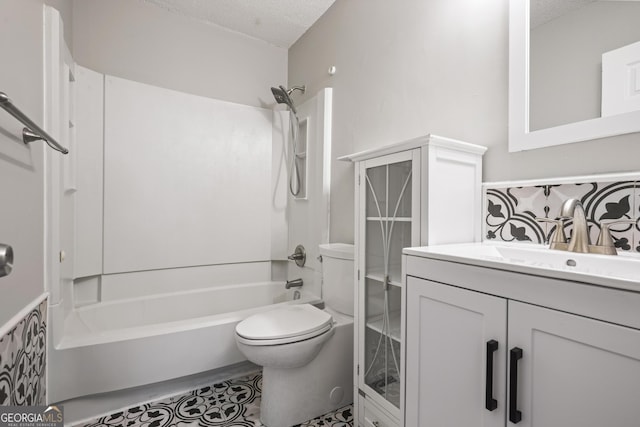 bathroom with vanity, a textured ceiling, shower / tub combination, and toilet