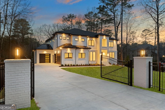 contemporary house with a gate, a standing seam roof, concrete driveway, a fenced front yard, and metal roof