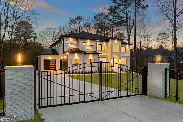 gate at dusk with a fenced front yard and a yard