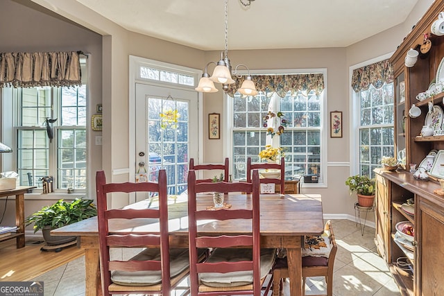 dining room with light tile patterned floors, baseboards, and an inviting chandelier