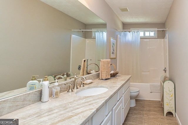 full bathroom with visible vents, toilet, shower / tub combo with curtain, wood finished floors, and vanity