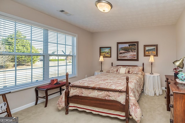 bedroom with visible vents, baseboards, and light colored carpet