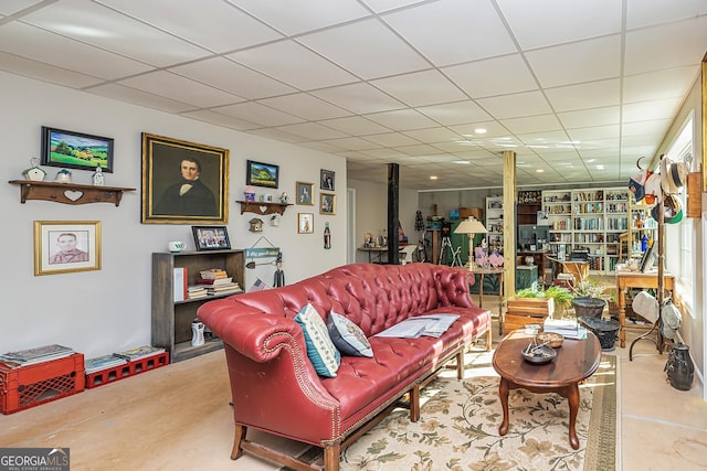 living room featuring a paneled ceiling and a wood stove