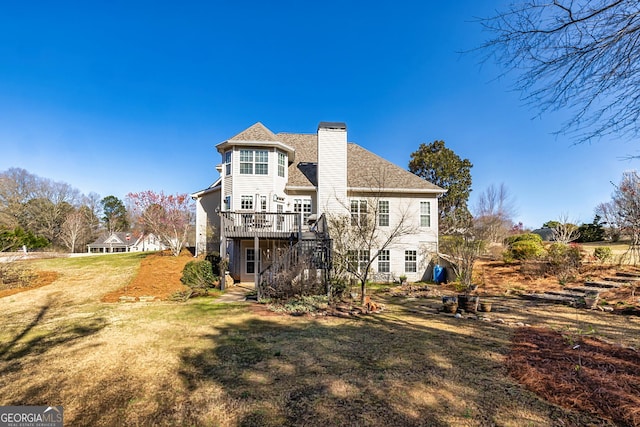 rear view of property with a wooden deck, a lawn, a chimney, and stairs