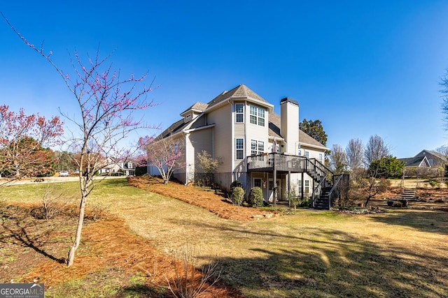 view of home's exterior featuring stairs, a deck, a yard, and a chimney