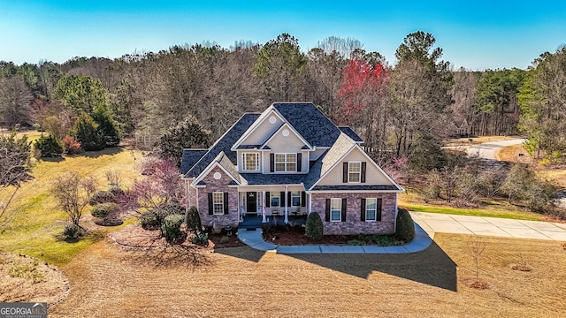 traditional-style house featuring a forest view and a front yard