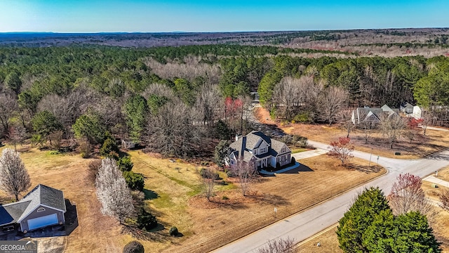 birds eye view of property featuring a wooded view