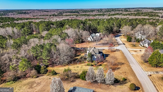 birds eye view of property featuring a forest view