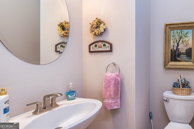 half bathroom featuring a sink and toilet