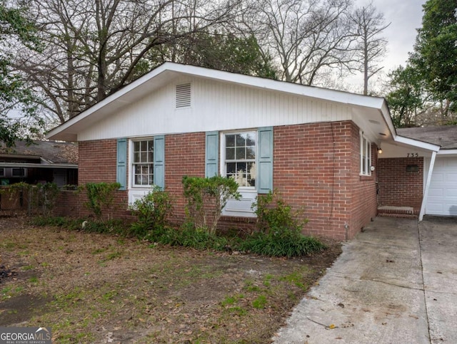 view of side of home with concrete driveway and brick siding