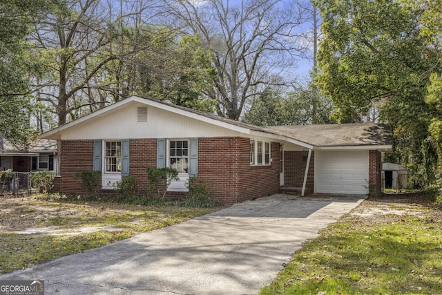 entrance to property with brick siding, concrete driveway, a garage, and fence