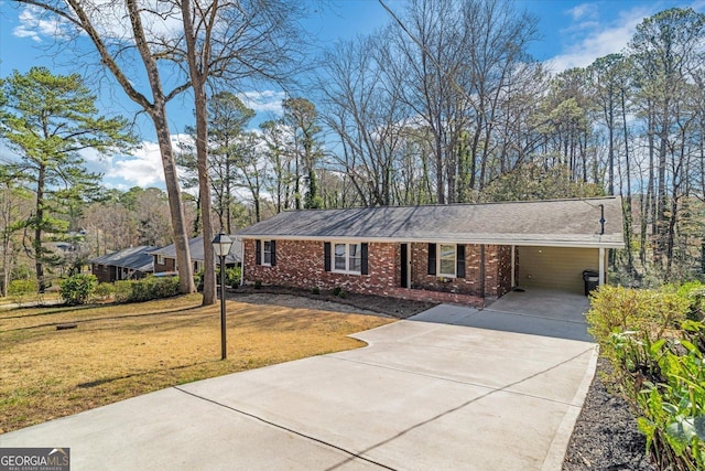 view of front of home with brick siding, an attached carport, concrete driveway, and a front yard