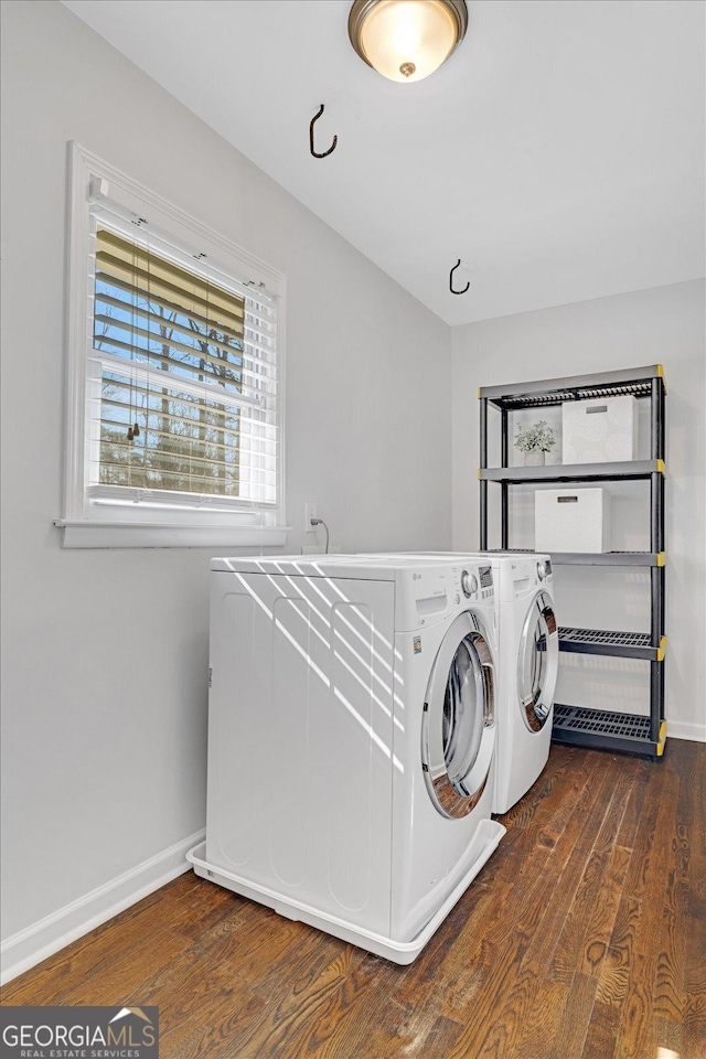 clothes washing area featuring washer and dryer, laundry area, baseboards, and dark wood-style flooring