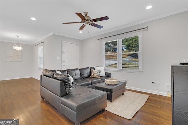 living area with a healthy amount of sunlight, dark wood-style floors, baseboards, and ornamental molding