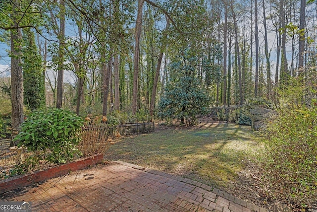 view of yard featuring a patio and a forest view