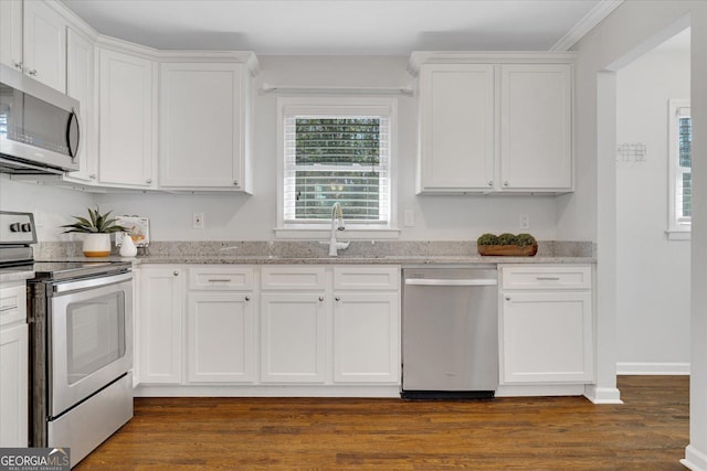 kitchen featuring dark wood-type flooring, white cabinets, light stone countertops, and stainless steel appliances