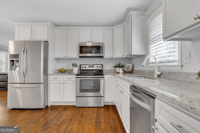 kitchen featuring dark wood finished floors, white cabinets, stainless steel appliances, and a sink