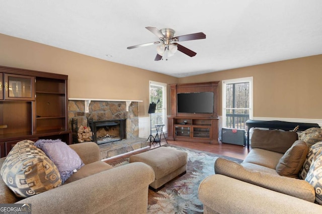 living room with wood finished floors, a fireplace, and ceiling fan