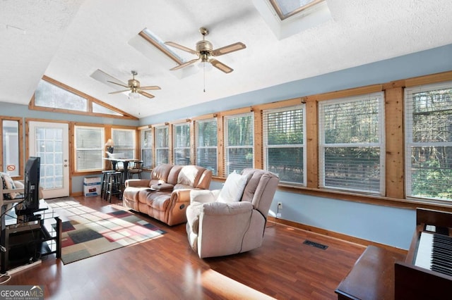 living room with lofted ceiling with skylight, wood finished floors, visible vents, and a healthy amount of sunlight