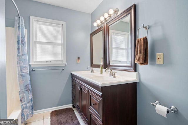 bathroom with a sink, a healthy amount of sunlight, tile patterned floors, and double vanity