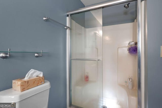 bathroom featuring a shower stall and toilet