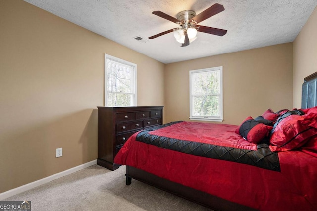 bedroom with visible vents, baseboards, carpet floors, and a textured ceiling