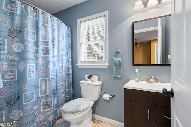 full bathroom featuring vanity, baseboards, tile patterned flooring, a textured ceiling, and toilet