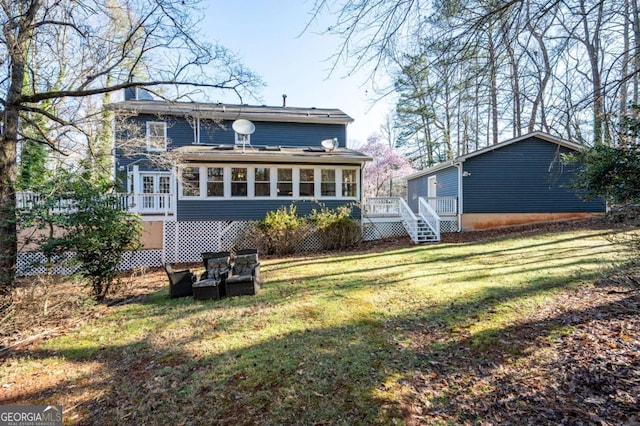 back of house with a deck, a yard, stairs, and a sunroom