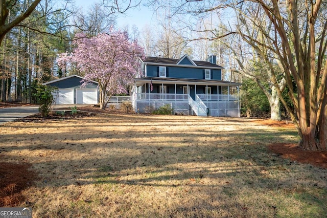 view of front facade featuring an outbuilding, a porch, a chimney, and a front lawn