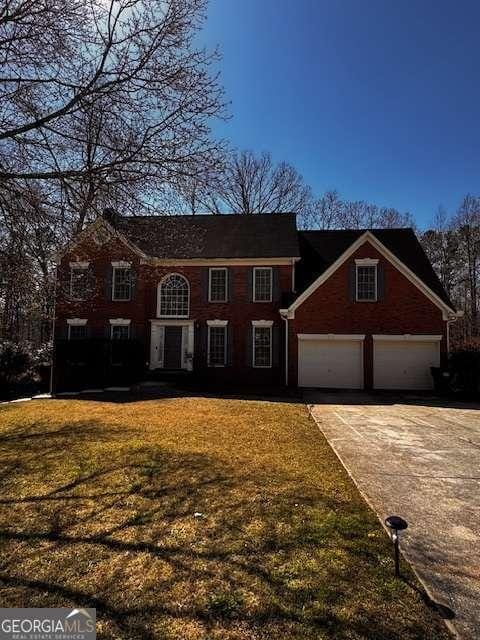 view of front facade featuring driveway, a front yard, and a garage