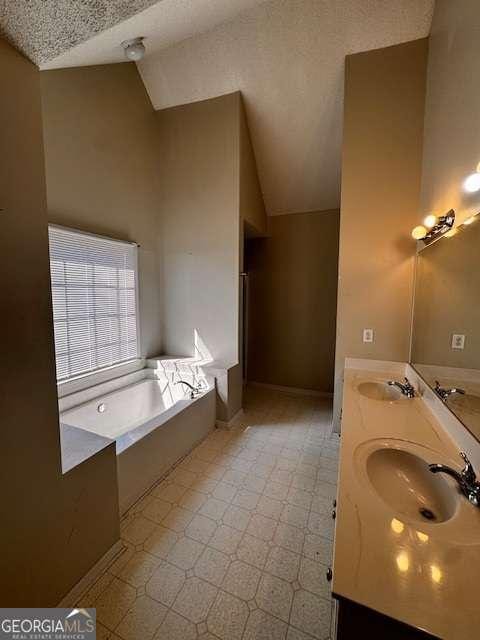 full bath featuring a sink, a bath, double vanity, and vaulted ceiling