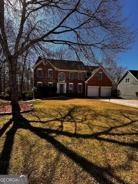 view of front of house with a garage, concrete driveway, and a front yard