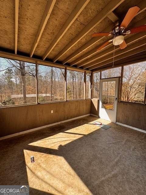 unfurnished sunroom featuring a wealth of natural light and ceiling fan