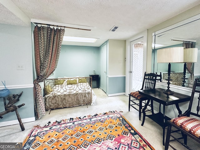 sitting room featuring visible vents, baseboards, and a textured ceiling