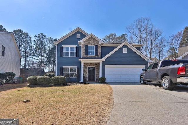 view of front of house with stone siding, a garage, concrete driveway, and a front lawn