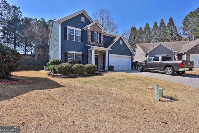 traditional-style house with stone siding, concrete driveway, a garage, and a front yard