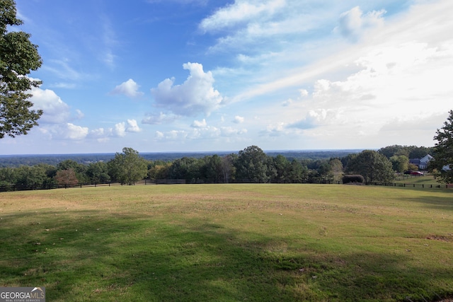 view of yard featuring a rural view and fence