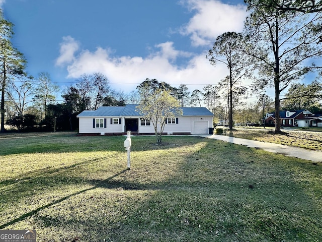 view of front of home with driveway, an attached garage, a front lawn, and metal roof