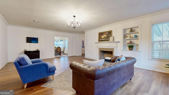 living area with wood finished floors, a chandelier, and a textured ceiling