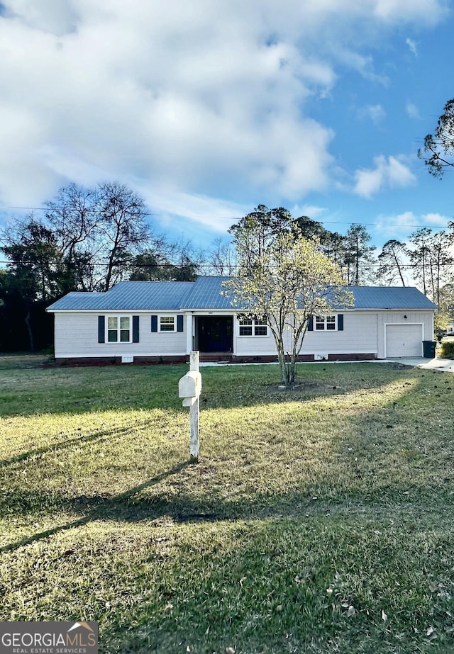 view of front facade with metal roof, an attached garage, and a front lawn