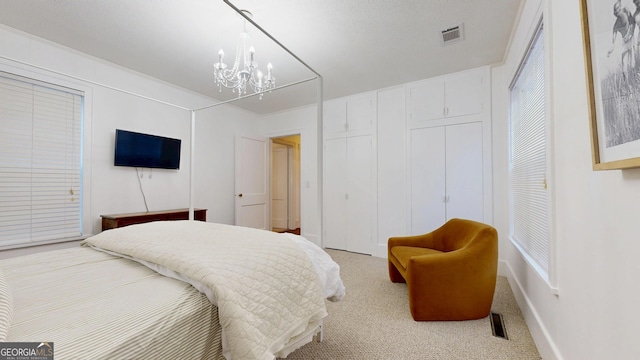 carpeted bedroom featuring a chandelier and visible vents