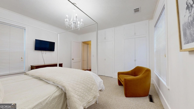 carpeted bedroom with visible vents and a notable chandelier
