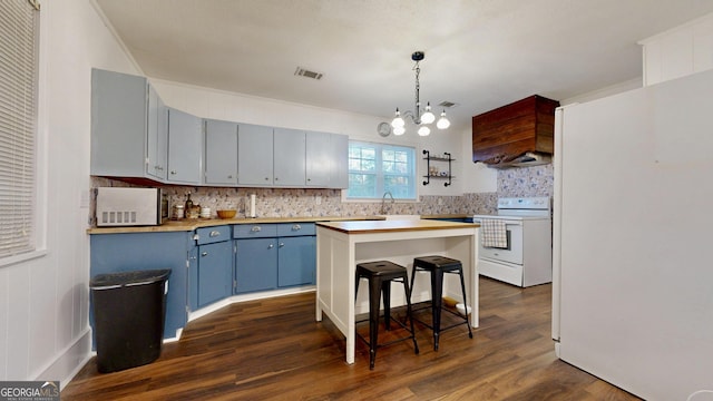 kitchen with visible vents, a kitchen breakfast bar, dark wood-style floors, white appliances, and blue cabinets