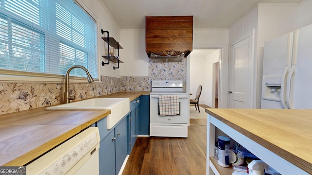 kitchen with blue cabinetry, open shelves, a sink, white appliances, and butcher block counters