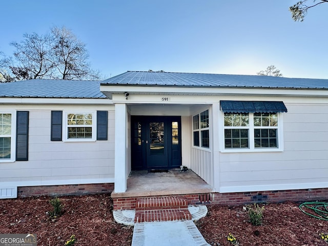 doorway to property with crawl space and metal roof