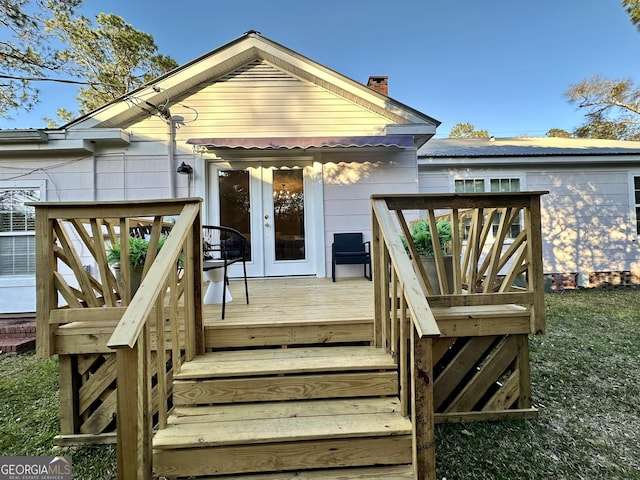 back of house with a deck, french doors, and a chimney