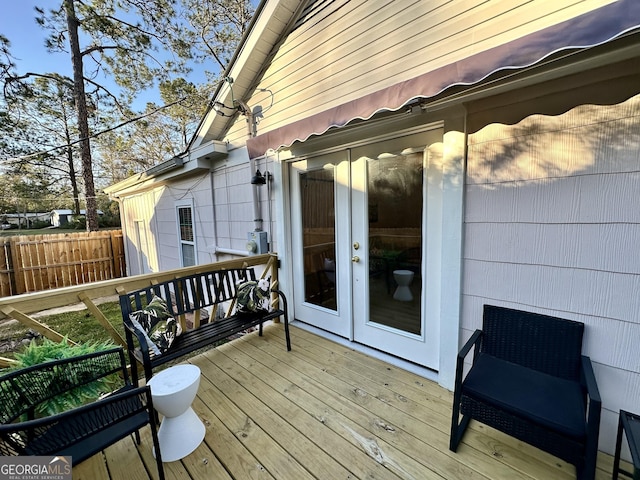 wooden terrace featuring french doors and fence