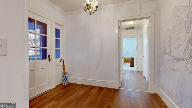 interior space featuring wood finished floors, visible vents, baseboards, crown molding, and a chandelier